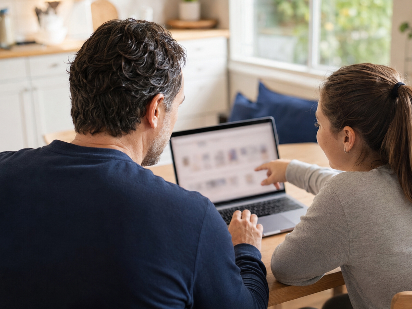 Parent and child shopping together on a laptop at home
